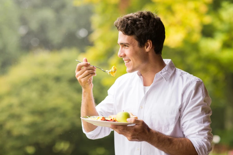 A man outside enjoying his breakfast.