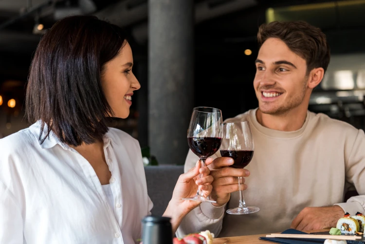 A man and woman toasting with wine.